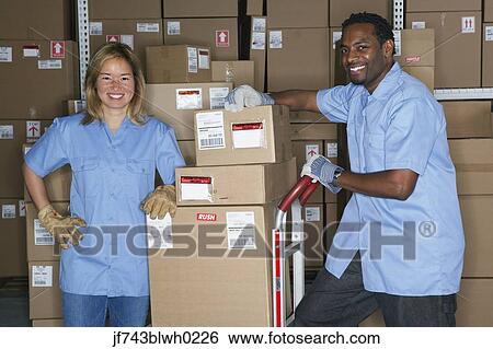 Stock Photograph - Male and female warehouse workers in warehouse. Fotosearch