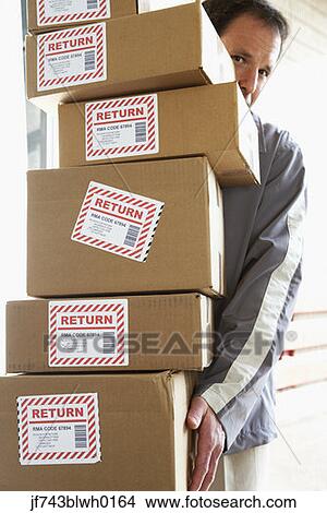 Man carrying stack of returned packages View Large Photo Image Picture - Man carrying stack of returned packages. Fotosearch