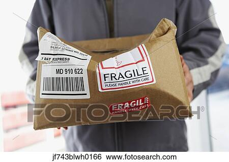 Stock Photograph - Man holding crushed package marked Fragile. Fotosearch