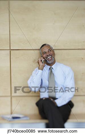 Middle-aged African businessman talking on cell phone View Large Photo Image Stock Photography - Middle-aged African businessman talking on cell phone. Fotosearch