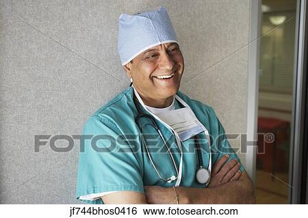Stock Photograph - Middle-aged Indian male surgeon laughing. Fotosearch