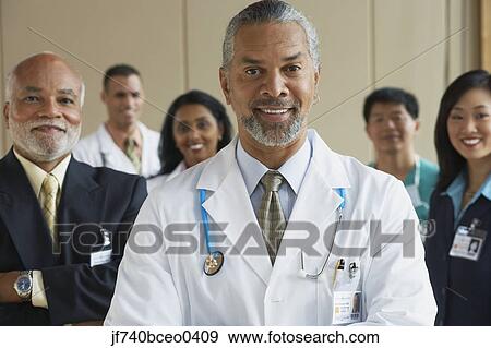 Stock Photo - Middle-aged male African doctor with co-workers in the background. Fotosearch