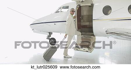 Middle-aged man boarding airplane in hanger, Nobato, California, United States View Large Photo Image Stock Photo - Middle-aged man boarding airplane in hanger, Nobato, California, United States. Fotosearch
