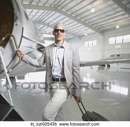 Middle-aged man boarding airplane in hanger, Nobato, California, United States View Large Photo Image Stock Photography - Middle-aged man boarding airplane in hanger, Nobato, California, United States. Fotosearch