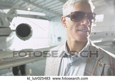 Middle-aged man next to airplane in hanger, Nobato, California, United States View Large Photo Image Stock Image - Middle-aged man next to airplane in hanger, Nobato, California, United States. Fotosearch
