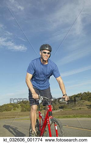 Middle-aged man riding a bicycle on a rural road, California, United States View Large Photo Image Picture - Middle-aged man riding a bicycle on a rural road, California, United States. Fotosearch