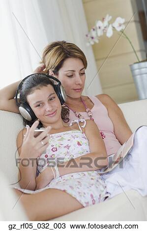 Mother and daughter sitting on sofa View Large Photo Image Stock Image - Mother and daughter sitting on sofa. Fotosearch