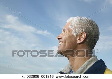 Stock Photograph - Profile of middle-aged man under blue sky, California, United States. Fotosearch