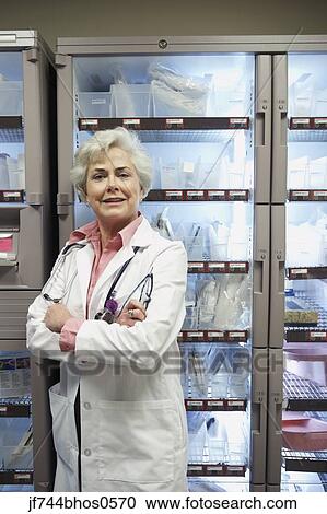 Stock Image - Senior female doctor in supply room, Bethesda, Maryland, United States. Fotosearch