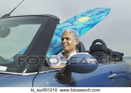 Senior man driving a convertible with a surfboard in it, Oakland, California, United States View Large Photo Image Stock Image - Senior man driving a convertible with a surfboard in it, Oakland, California, United States. Fotosearch