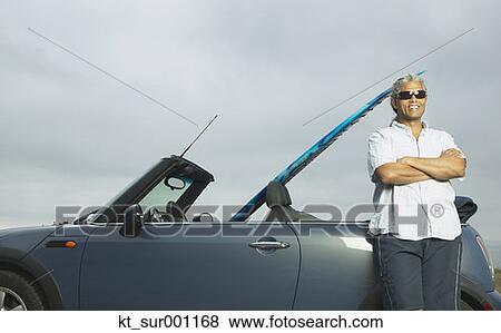 Senior man leaning on a convertible with a surfboard in it, Oakland, California, United States View Large Photo Image Stock Photo - Senior man leaning on a convertible with a surfboard in it, Oakland, California, United States. Fotosearch