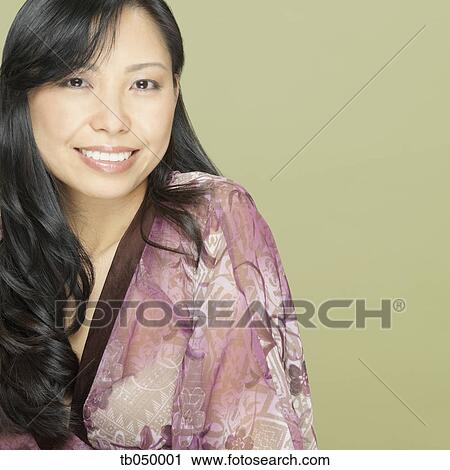 Stock Image - Studio shot close up of Asian woman smiling. Fotosearch