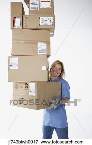 Stock Photo - Studio shot of female warehouse worker carrying packages. Fotosearch