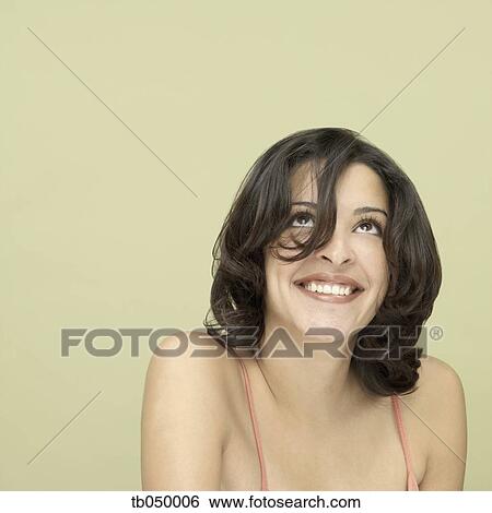 Stock Photograph - Studio shot of young Hispanic woman smiling. Fotosearch