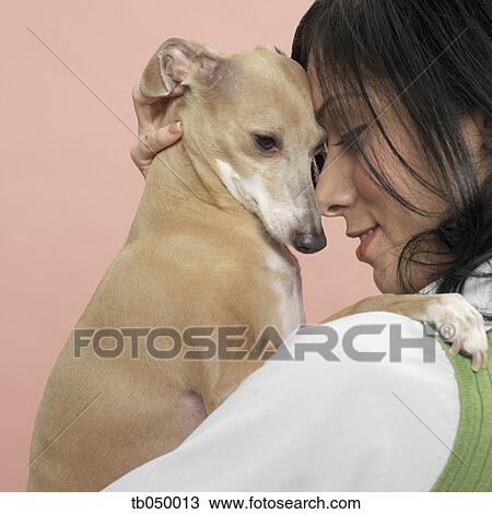 Stock Image - Studio shot of young woman and dog. Fotosearch