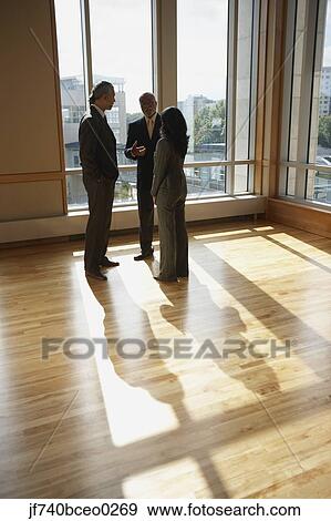Three businesspeople talking in sunlit room, North Bethesda, Maryland, United States View Large Photo Image Stock Photo - Three businesspeople talking in sunlit room, North Bethesda, Maryland, United States. Fotosearch