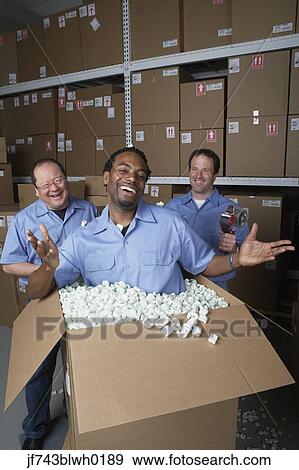 Three male warehouse workers joking around View Large Photo Image Stock Photo - Three male warehouse workers joking around. Fotosearch