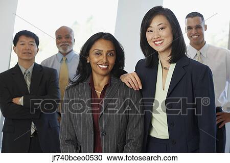 Two businesswoman with co-workers in the background View Large Photo Image Stock Image - Two businesswoman with co-workers in the background. Fotosearch