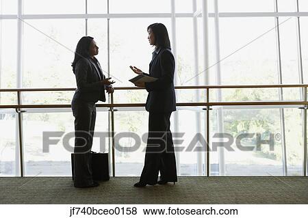 Two businesswomen talking at railing, North Bethesda, Maryland, United States View Large Photo Image Stock Photo - Two businesswomen talking at railing, North Bethesda, Maryland, United States. Fotosearch