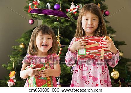 Two young sisters with Christmas presents View Large Photo Image Stock Photograph - Two young sisters with Christmas presents . Fotosearch