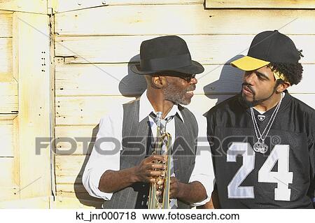 Young African man talking to senior African man with trumpet, Oakland, California, United States View Large Photo Image Stock Photo - Young African man talking to senior African man with trumpet, Oakland, California, United States. Fotosearch