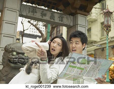 Stock Photo - Young Asian couple looking at a map, San Francisco, California, United States. Fotosearch