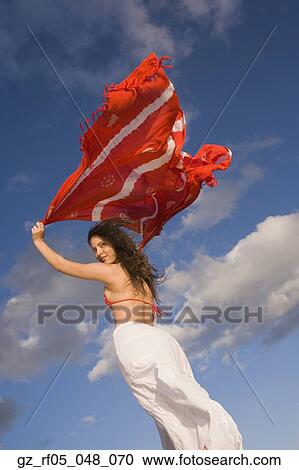 Young woman holding shawl over her head in the wind View Large Photo Image Stock Image - Young woman holding shawl over her head in the wind. Fotosearch