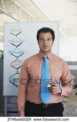 African American businessman in front of white board with chart View Large Photo Image Stock Photo - African American businessman in front of white board with chart. Fotosearch
