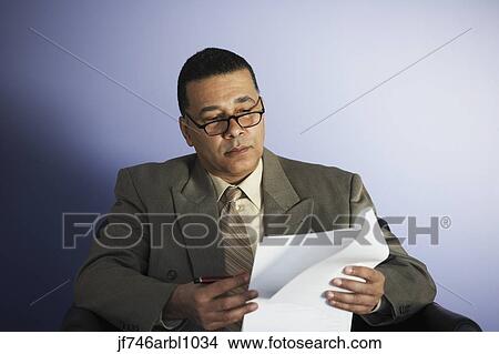 African American businessman reading paperwork View Large Photo Image Picture - African American businessman reading paperwork. Fotosearch