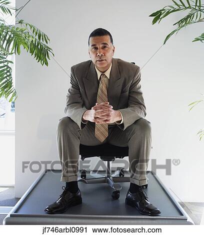 African American businessman sitting in chair on pedestal View Large Photo Image Stock Image - African American businessman sitting in chair on pedestal. Fotosearch