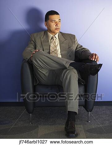 Stock Photo - African American businessman sitting in chair. Fotosearch