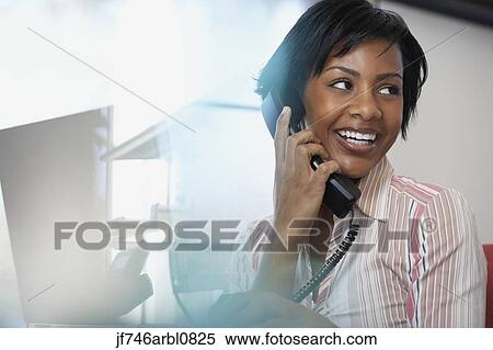 Stock Photography - African American businesswoman talking on telephone. Fotosearch