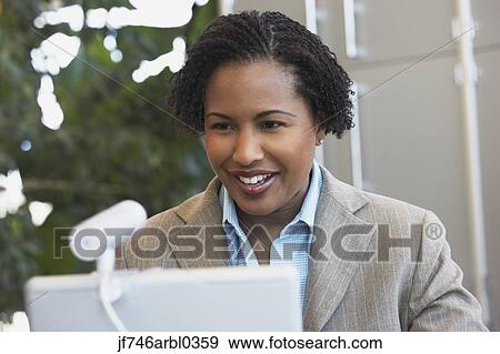 Stock Photo - African American businesswoman with laptop. Fotosearch