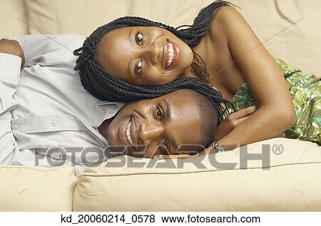 Stock Photo - African American couple lying on sofa. Fotosearch