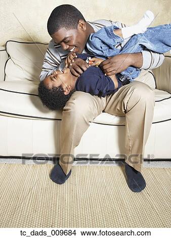African American father and young son playing on sofa View Large Photo Image Picture - African American father and young son playing on sofa. Fotosearch