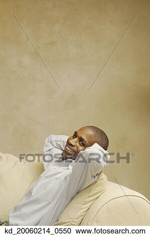 African American man sitting on sofa View Large Photo Image Stock Image - African American man sitting on sofa. Fotosearch