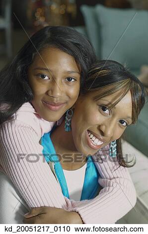 Stock Image - African American mother and daughter hugging. Fotosearch