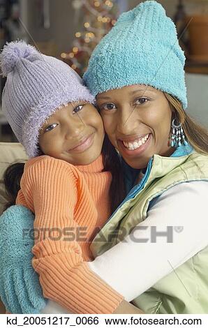 Stock Photograph - African American mother and daughter wearing winter hats. Fotosearch