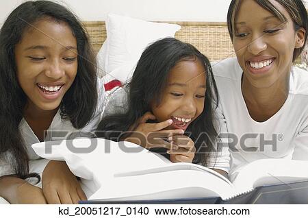 African American mother and daughters on bed with book View Large Photo Image Stock Image - African American mother and daughters on bed with book. Fotosearch