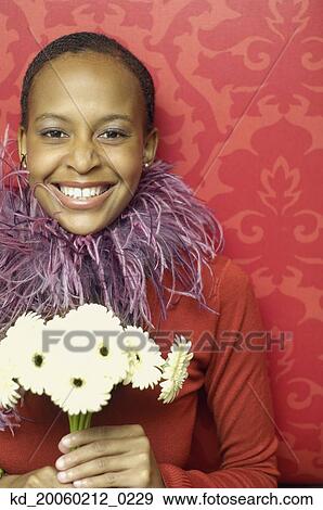 Stock Photo - African American woman holding flowers. Fotosearch