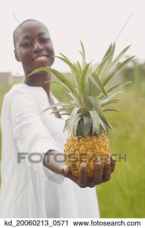 African American woman holding pineapple outdoors View Large Photo Image Stock Image - African American woman holding pineapple outdoors. Fotosearch
