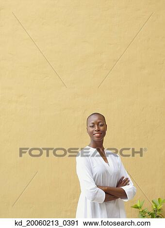 Stock Image - African American woman in front of blank wall outdoors. Fotosearch