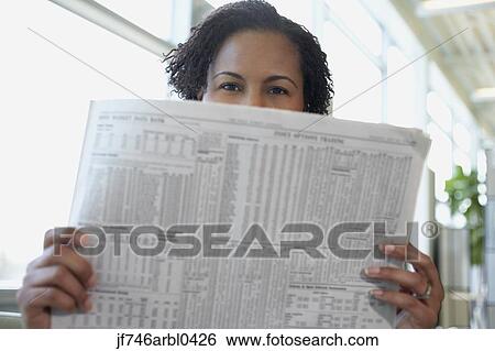 Stock Photograph - African American woman reading newspaper. Fotosearch