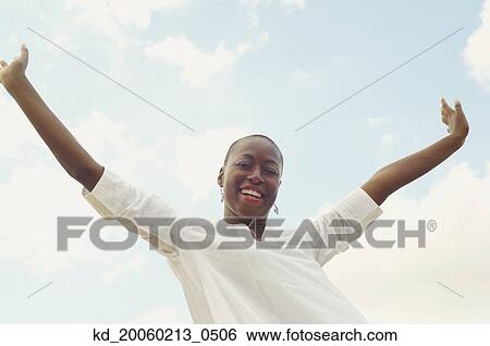 Stock Photograph - African American woman with arms raised. Fotosearch