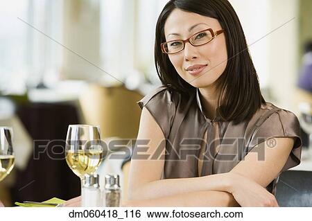 Stock Photograph - Asian businesswoman at restaurant. Fotosearch