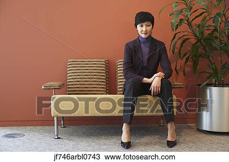 Stock Image - Asian businesswoman in waiting area. Fotosearch