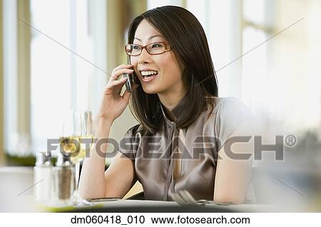 Asian businesswoman on cell phone in restaurant View Large Photo Image Stock Image - Asian businesswoman on cell phone in restaurant. Fotosearch