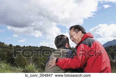 Asian father and son hugging outdoors View Large Photo Image Stock Photo - Asian father and son hugging outdoors. Fotosearch