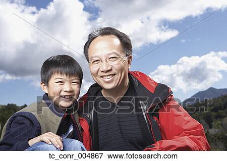 Stock Photo - Asian father and son smiling outdoors. Fotosearch