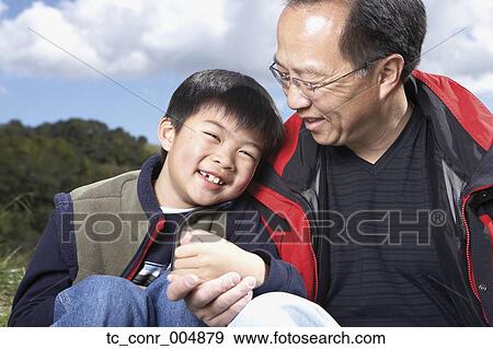 Stock Photo - Asian father and son smiling outdoors. Fotosearch